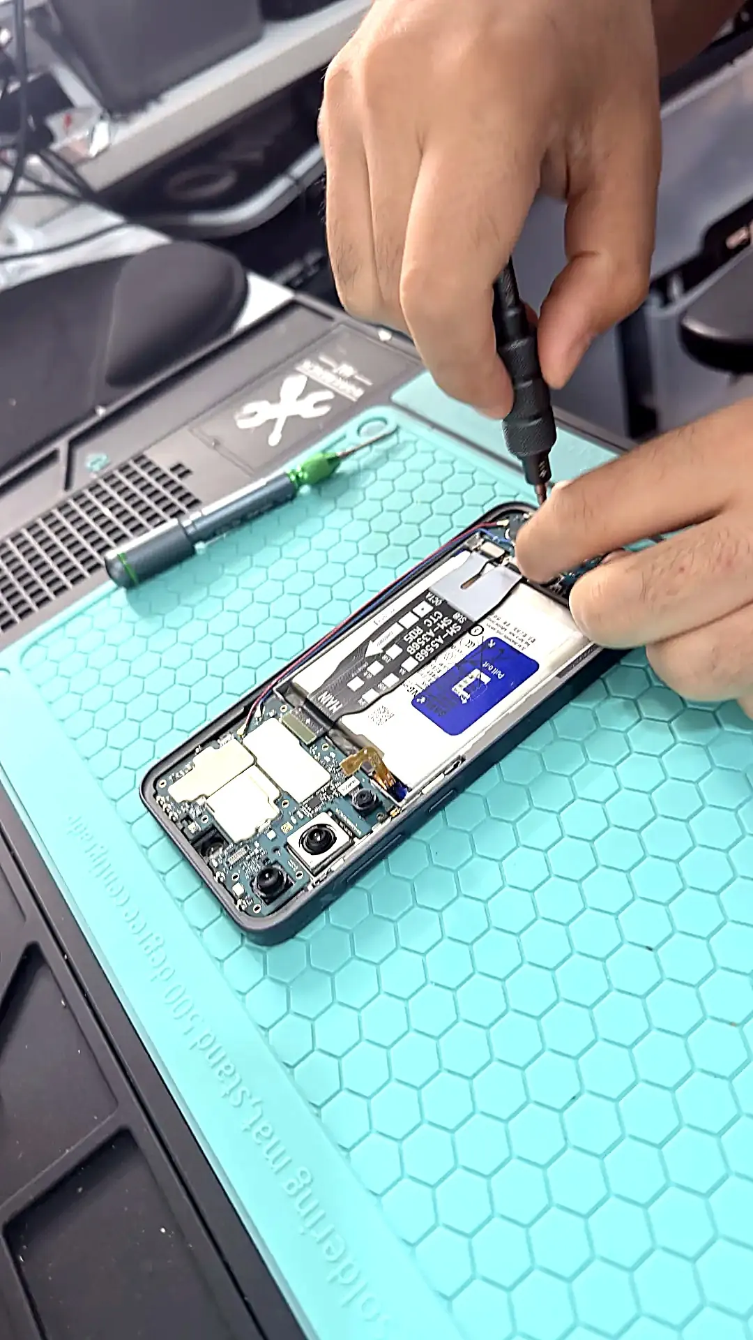 Technicus van Mobile Care herstelt een smartphonescherm in de werkplaats in Borgerhout